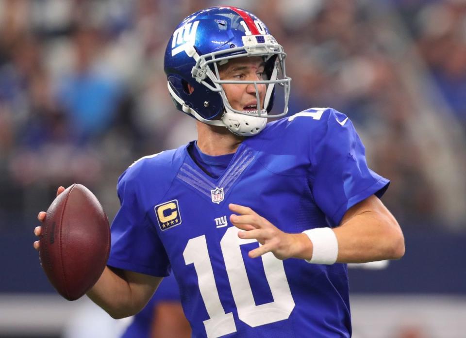 Eli Manning drops back to pass against the Dallas Cowboys (Photo by Tom Pennington/Getty Images).