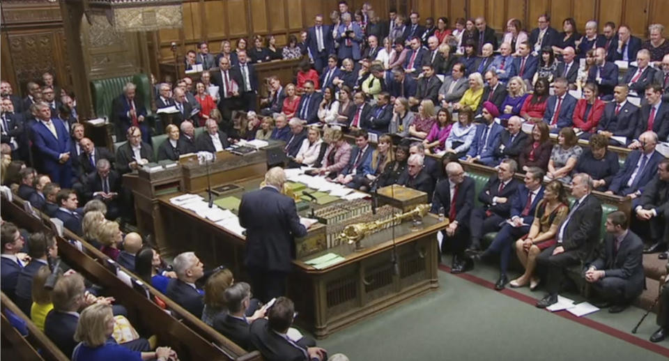 Britain's Prime Minister Boris Johnson stands facing the opposition lawmakers, as he delivers a statement to lawmakers inside a crowded House of Commons in London, Saturday Oct. 19, 2019. At a rare weekend sitting of Parliament, Johnson implored legislators to ratify the Brexit deal he struck this week with the other 27 EU leaders. (House of Commons via AP)