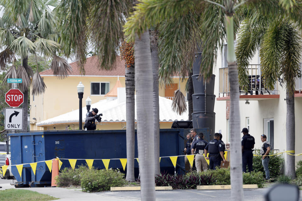 A crime scene investigator photographs the inside of a large trash bin outside of an apartment complex in Hollywood, Fla., where construction workers found a dead baby on Monday, Jan. 8, 2024. (Amy Beth Bennett/South Florida Sun-Sentinel via AP)