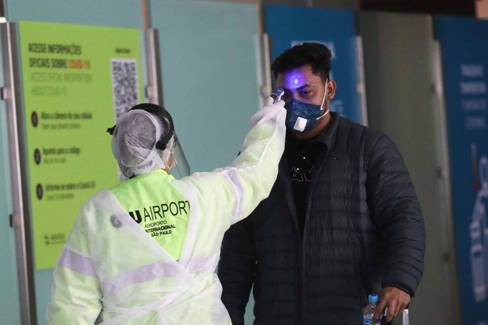 A man has his temperature checked at an airport in Guarulhos, near Sao Paulo, Brazil (REUTERS)