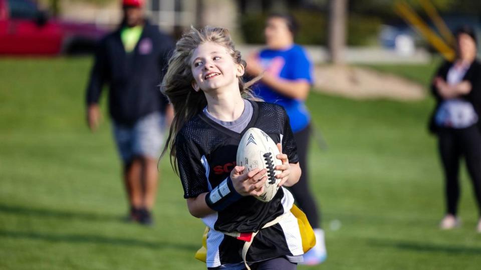 Lauren Ruhter, 11, runs from the defense at practice on April 17 at Settlers Park in Meridian. It is the inaugural season for girls flag football in the Treasure Valley.