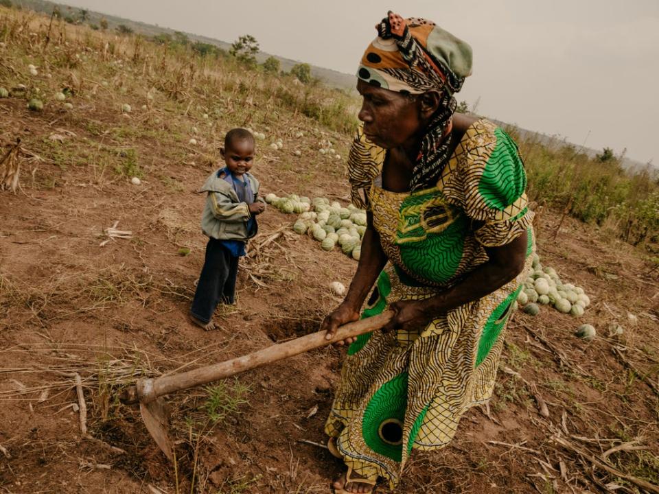 Jeannine*, 69, working on her crop field with her malnourished grandson Eriq*, 4 (© Hugh Kinsella Cunningham / Save the Children)