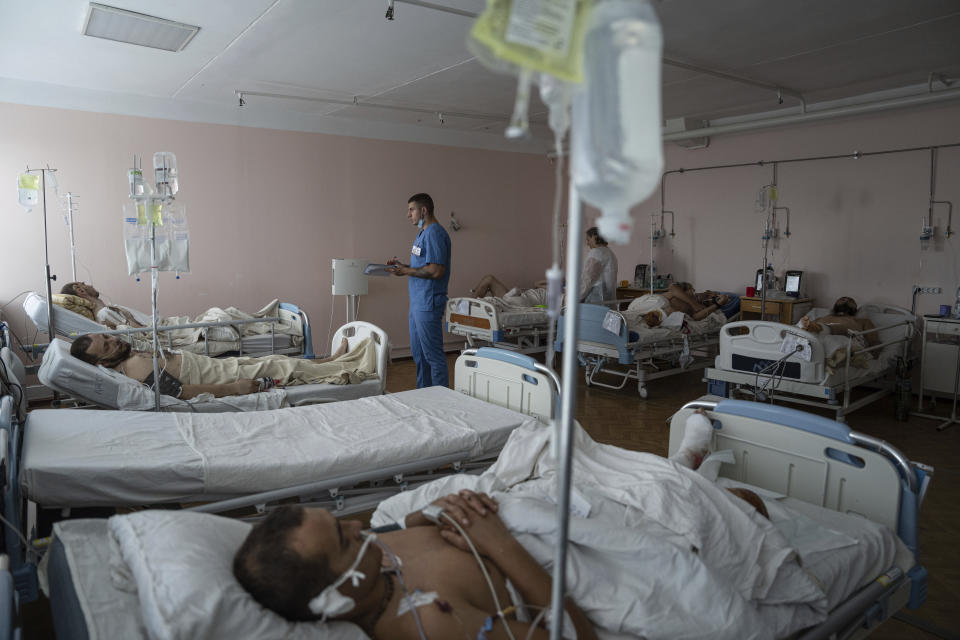 A doctor writes notes inside the ICU of Mechnikov Hospital in Dnipro, Ukraine, Saturday, July 15, 2023. A surge of wounded soldiers has coincided with the major counteroffensive Ukraine launched last month to try to recapture its land from Russian forces. Surgeons at Mechnikov Hospital, one of the country's biggest, are busier now than perhaps at any other time since Russia began its invasion 17 months ago. (AP Photo/Evgeniy Maloletka)