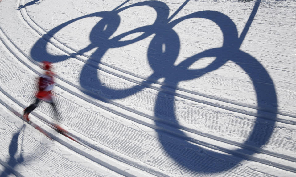 A cross-country skier passes by the shadows of the Olympic rings prior to the 2014 Winter Olympics, Thursday, Feb. 6, 2014, in Krasnaya Polyana, Russia. (AP Photo/Dmitry Lovetsky)