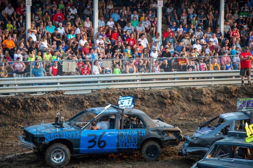 Fans watch as cars run into each other during the demolition derby at the Platte County Fair, Thursday, July 22, 2021, in Tracy, Missouri.