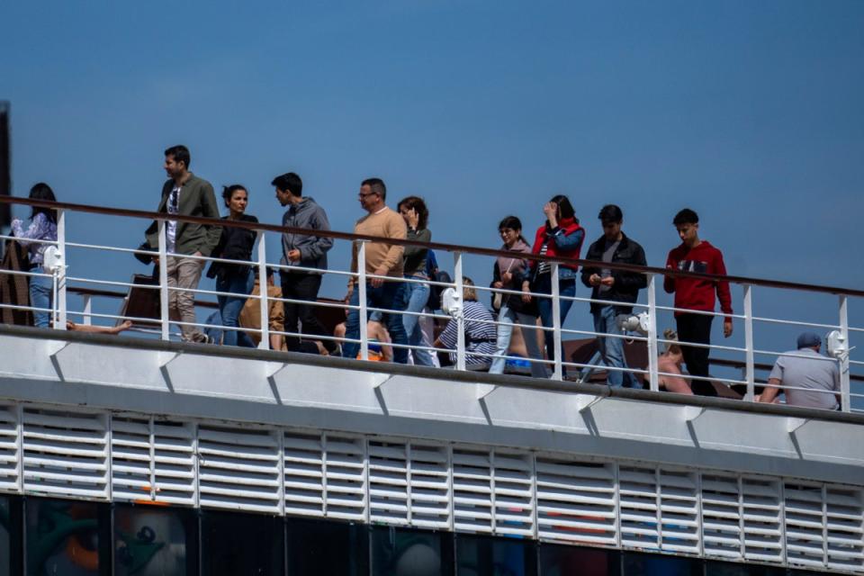 Passengers are photographed on the cruise ship moored in the port of Barcelona (AP)