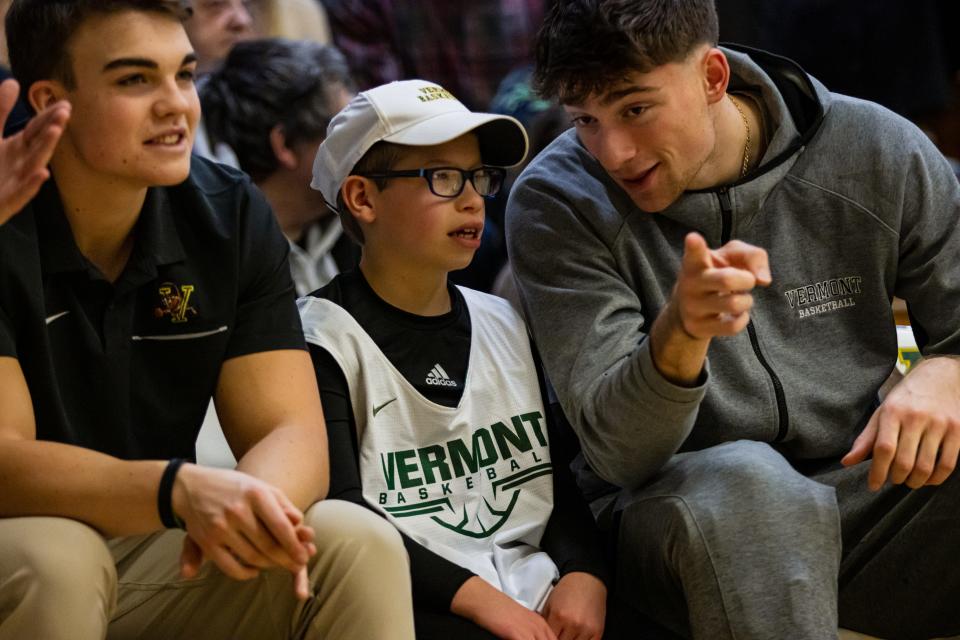 Dylan Schaeffler, center, listens to Vermont forward Nick Fiorillo during a UVM men's basketball game this season.