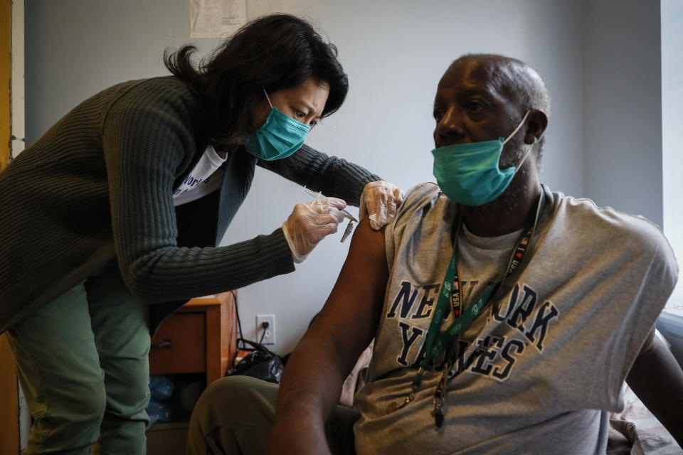 Dr. Jeanie Tse, chief medical officer at the Institute for Community Living, injects antipsychotic medication into the arm of Eugene, 67, in his room at Eastern Parkway Residences, Wednesday, May 6, 2020, in the Brooklyn borough of New York. (AP Photo/John Minchillo)