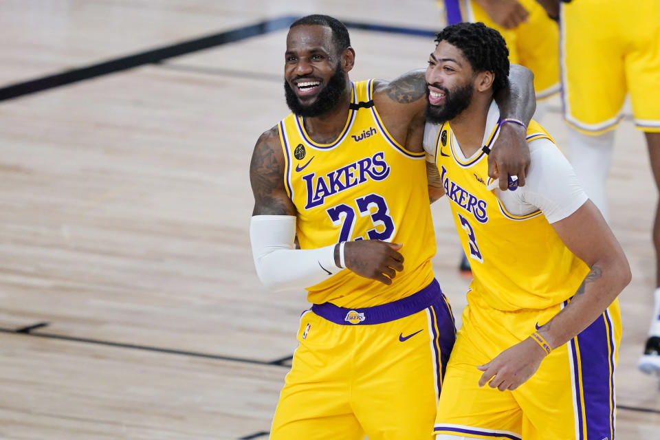 LeBron James (23) y Anthony Davis (3) de los Lakers de Los Ángeles celebran tras la victoria ante los Nuggets de Denver, el lunes 10 de agosto de 2020, en Lake Buena Vista, Florida. (AP Foto/Ashley Landis, Pool)