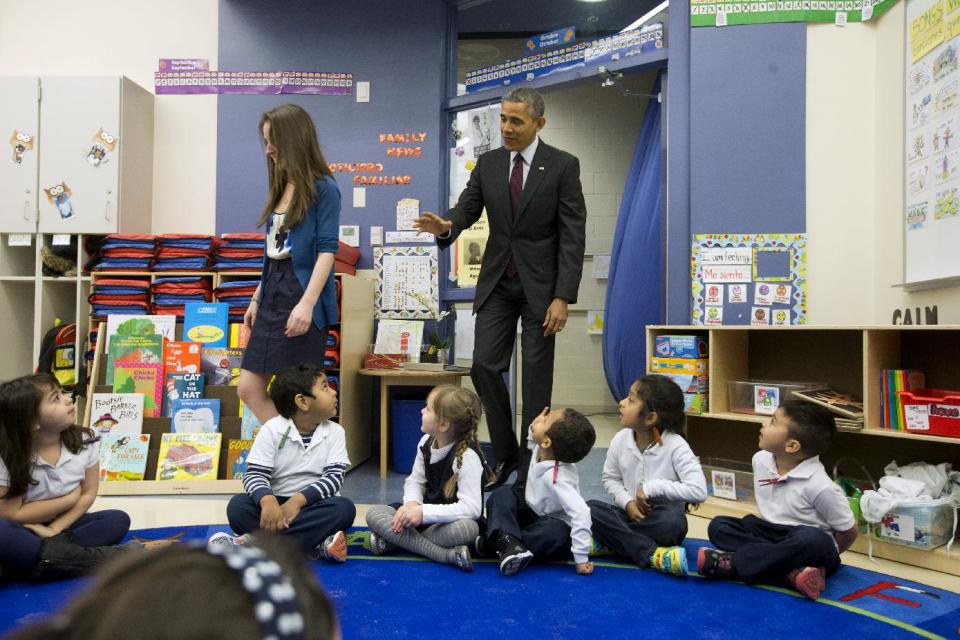 President Barack Obama waves to preschool students as he follows teacher Laura Steinmetz during his visit to the classroom at Powell Elementary School in the Petworth neighborhood of Washington, Tuesday, March 4, 2014. Obama visited the school to talk about his fiscal 2015 budget proposal, which was released today. Powell elementary has seen rapid growth in recent years and serves a predominantly Hispanic student body. Washington DC Mayor Vincent Gray, who greeted Obama at the school, recently directed $20 million to Powell for a planned modernization and addition. (AP Photo/Pablo Martinez Monsivais)