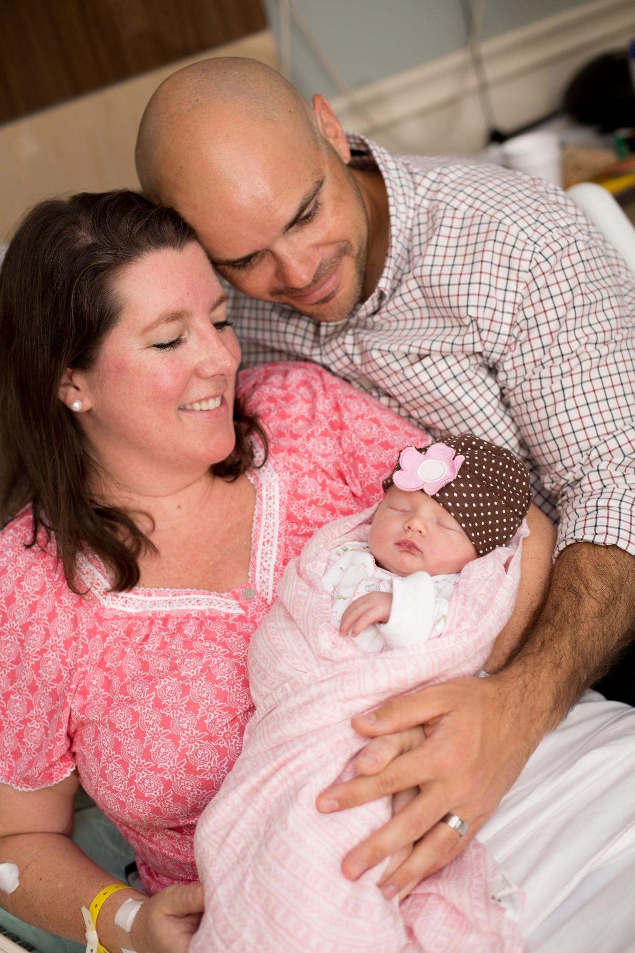Kristin Dillensnyder and her husband in 2017, with their daughter, Grace, who was born via IVF.