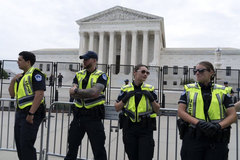 U.S. Capitol police officers watch demonstrators protest outside of the U.S. Supreme Court on Capitol Hill in Washington, Tuesday, June 21, 2022. (AP Photo/Jose Luis Magana)