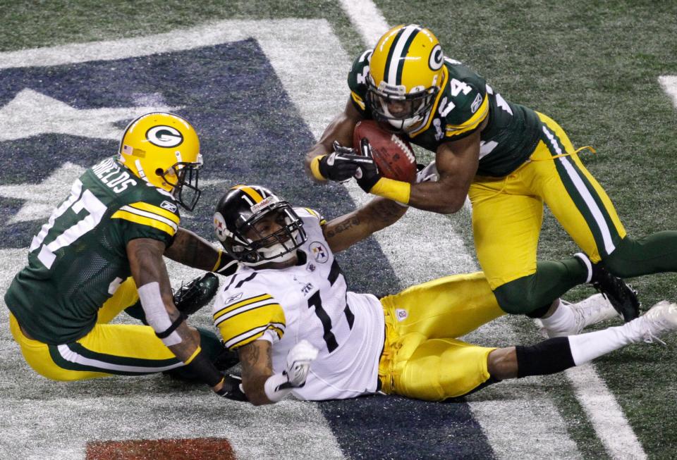 Green Bay Packers cornerback Jarrett Bush (24) intercepts a pass intended for Pittsburgh Steelers wide receiver Mike Wallace (17) as Packers Sam Shields (37) looks on in the second half of Super Bowl XLV, in Arlington, Texas, Sunday, February 6, 2011.