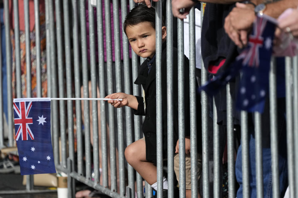 A young boy holds an Australian flag as he watches the Anzac Day march in Sydney, Monday, April 25, 2022. Australia and New Zealand commemorate Anzac Day every April 25, the date in 1915 when the Australia and New Zealand Army Corps landed on Turkey in an ill-fated campaign that created the soldiers' first combat of World War I. (AP Photo/Rick Rycroft)