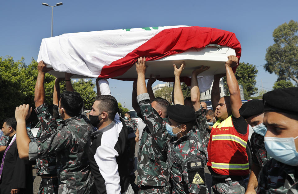 Firefighters carry the coffin of one of their ten colleagues who were killed during the Aug. 4 explosion that hit the seaport of Beirut, during their funerals at the firefighter headquarters, in Beirut, Lebanon, Monday, Aug. 17, 2020. (AP Photo/Hussein Malla)