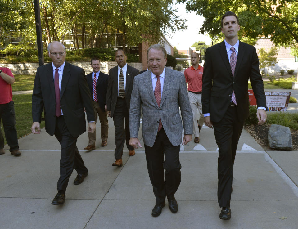 University of Louisville interim President Greg Postel, center, walks with David Padgett, right, to a press conference where it was announced that Padgett will be Louisville’s interim men’s basketball. (AP)