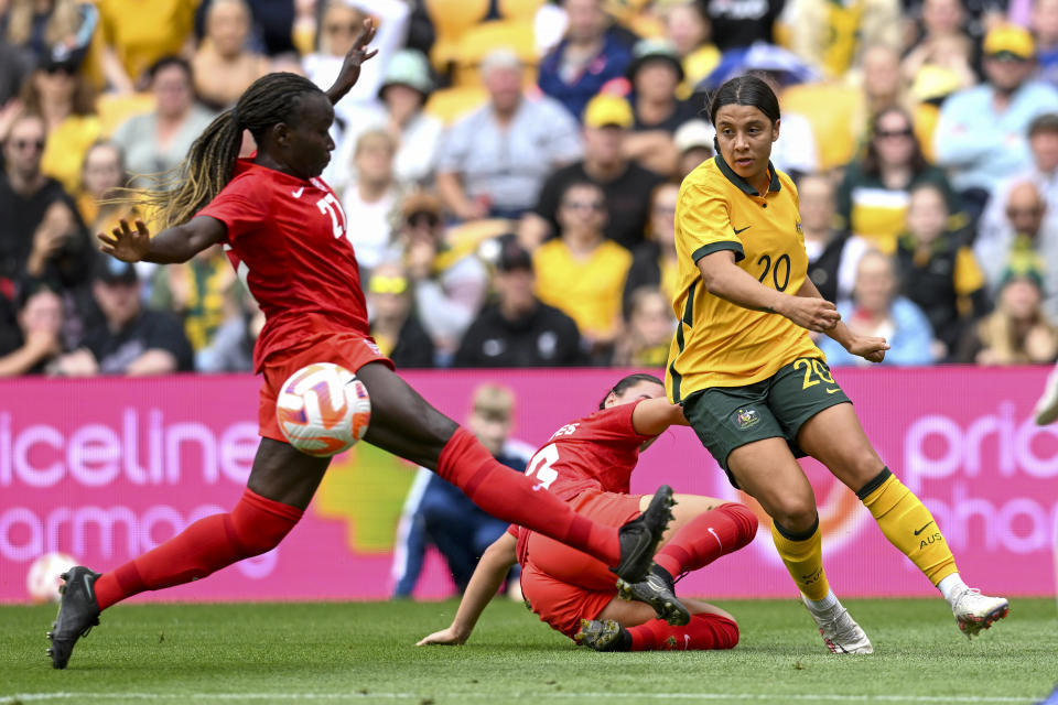 Sam Kerr, right, of Australia, is tackled by Sura Yekka, left, and Bianca St. Georges of Canada during the women's soccer friendly between Australia and Canada at Suncorp Stadium in Brisbane, Australia, Saturday, Sept. 3, 2022. (Darren England/AAP Image via AP)