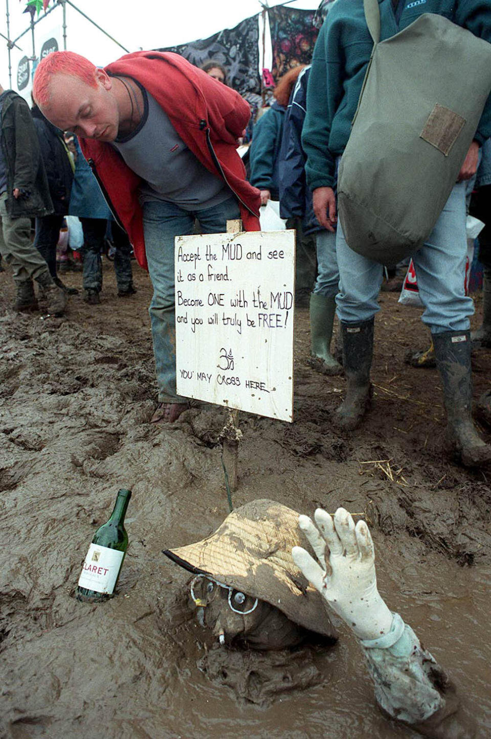 A sign tells festival-goers in 1997 to ‘accept the mud and see it as a friend’. (Jon Mills)