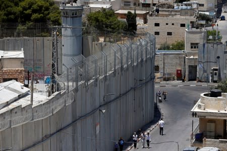 People walk past a section of the Israeli barrier in Bethlehem, in the Israeli-occupied West Bank