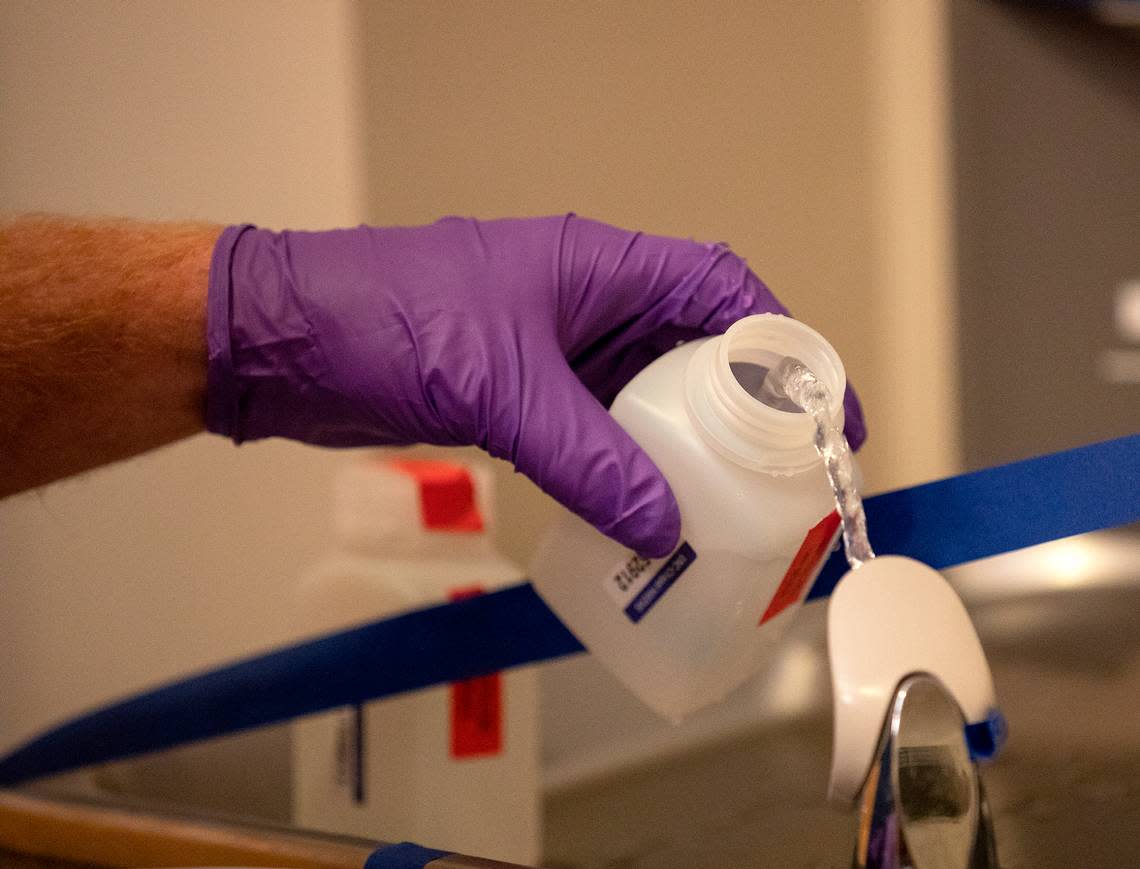 David Catalano, a field hygienist with UNC’s Department of Environment, Health and Safety, collects a sample from a water fountain to test for lead inside Bynum Hall on the university’s campus on Friday, Oct. 28, 2022.