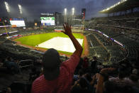 A fan dances in the rain before a rain-delayed baseball game between the Atlanta Braves and the San Diego Padres, Saturday, May 18, 2024, in Atlanta. (AP Photo/Mike Stewart)