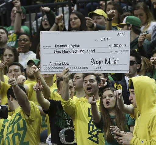 Fans in the Oregon student section hold up a sign making fun of the controversy surrounding Arizona coach Sean Miller, during the first half of an NCAA college basketball game Saturday, Feb. 24, 2018, in Eugene, Ore. (AP photo/Chris Pietsch)