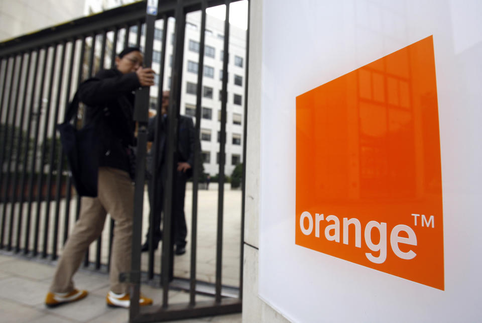 FILE - In this Oct.29, 2009 file photo, people enter the headquarters of France Telecom SA in Paris. French telecom giant Orange and seven former or current managers are going on trial Monday May 6, 2019, accused of moral harassment over a wave of employee suicides a decade ago. (AP Photo/Christophe Ena, File)