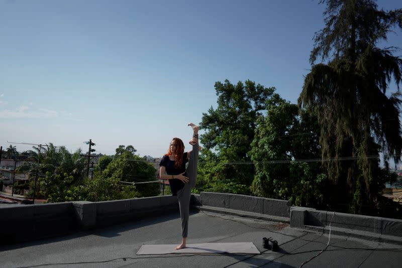 Foto de la bailarina Arelys Hernandez actuando ante una cámara de TV (fuera de la imagen) en la terraza de su casa en La Habana, en medio de la pandemia del coronavirus