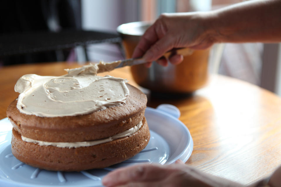 person icing a cake