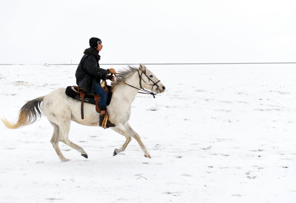 A horseback rider moves across a snowy plain during the Dakota 38+2 Memorial Ride on Wednesday, December 14, 2022. The horseback journey stretches from the Lower Brule Sioux Tribe to Mankato, MN, commemorating Dakota warriors who died in the largest single-day mass execution in the country on Dec. 26, 1862.