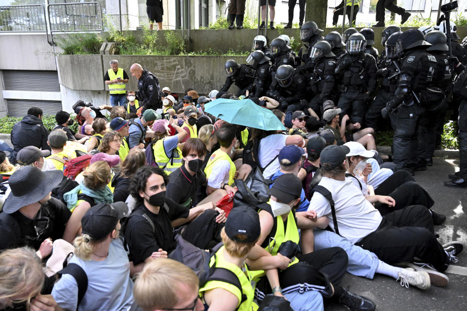 Not far from the Grugahalle, demonstrators have gathered to form a sit-in blockade, which is being broken up by the police, in Essen, Germany, Saturday, June 29, 2024. The two-day national party conference of the AfD is taking place in the Grugahalle, including the election of the federal executive committee. Numerous organizations have announced opposition to the meeting and more than a dozen counter-demonstrations. (Henning Kaiser/dpa via AP)