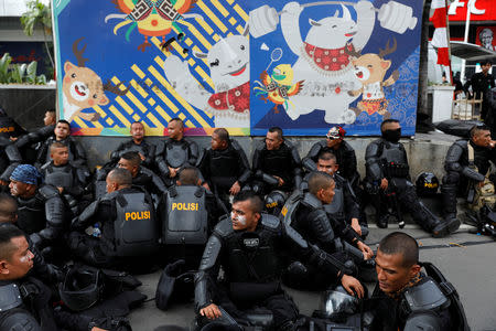 Mobile brigade (Brimob) police officers sit as they take a rest during a protest following the announcement of last month's election official results outside Indonesia's Election Supervisory Agency (Bawaslu) headquarters in Jakarta, Indonesia, May 22, 2019. REUTERS/Willy Kurniawan