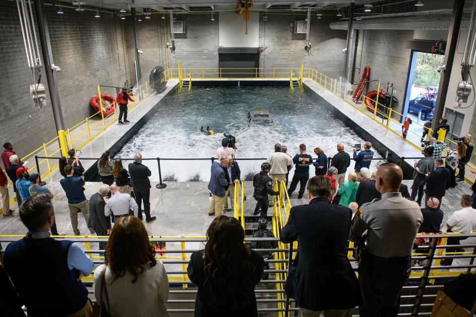 People stand around and watch a rescue demonstration after a ribbon cutting ceremony at Fayetteville Technical Community College’s swift water rescue training facility on Monday, Nov. 13, 2023.
