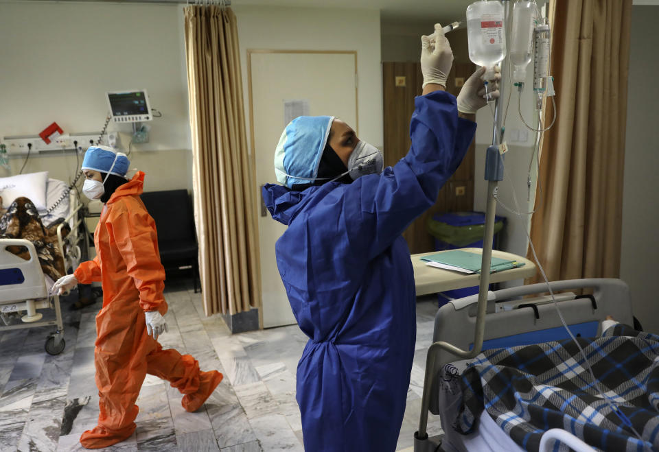 FILE - In this June 16, 2020, file photo, nurses tend to COVID-19 patients at the Shohadaye Tajrish Hospital in Tehran, Iran. As coronavirus infections reached new heights in Iran, overwhelming its hospitals and driving up its death toll, the country’s health minister gave a rare speech criticizing his own government’s refusal to enforce basic health measures. (AP Photo/Vahid Salemi, File)