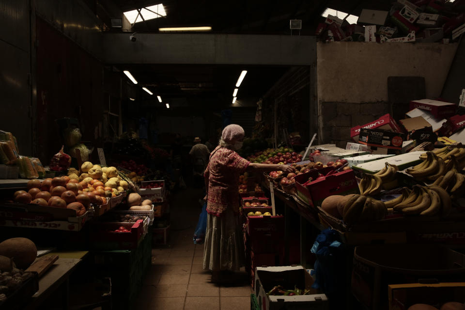 A woman shops in the town of Ashkelon, Israel, Friday, May 21, 2021, aafter a cease-fire took effect between Hamas and Israel. The 11-day war between Israel and Hamas left more than 200 dead — the vast majority Palestinians — and brought widespread devastation to the already impoverished Hamas-ruled Gaza Strip. (AP Photo/Maya Alerruzzo)