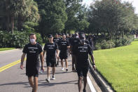 NBA referees march in support of players seeking an end to racial injustice in Lake Buena Vista, Fla., Thursday, Aug. 27, 2020. Their march came shortly before players met to decide on restarting the season after three games were postponed Wednesday. (AP Photo/Brian Mahoney)