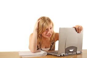 BWET1M A stressed student in front of her notebook computer. All isolated on white background.