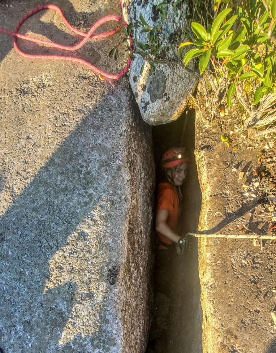 This photo provided by New York State Parks on Wednesday, Oct. 13, 2021, shows Jessica Van Ord entering a fissure to rescue a 12-year-old dog named Liza, found trapped after five days deep inside the narrow, rocky crevice at Minnewaska State Park Preserve in Kerhonkson, N.Y. (AP)