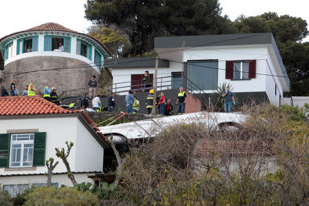 Rescue workers stand next to the wreckage of a bus after an accident in Canico, in the Portuguese Island of Madeira, April 17, 2019. REUTERS/Duarte Sa