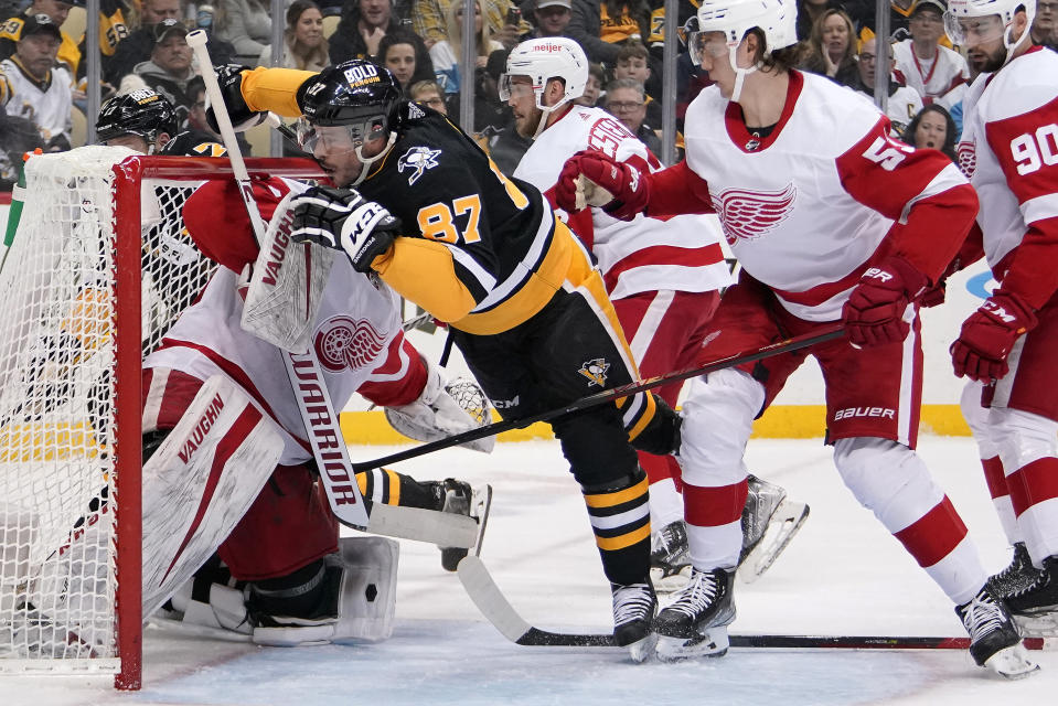 Pittsburgh Penguins' Sidney Crosby (87) collides with Detroit Red Wings goaltender Calvin Pickard (31) during the second period of an NHL hockey game in Pittsburgh, Friday, Jan. 28, 2022. (AP Photo/Gene J. Puskar)