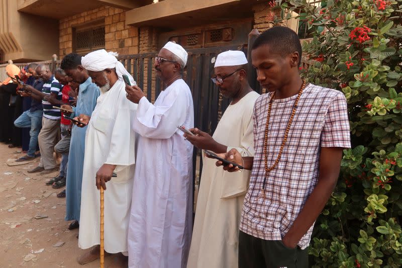 Residents and displaced people try to access the internet via Starlink in the city of Omdurman