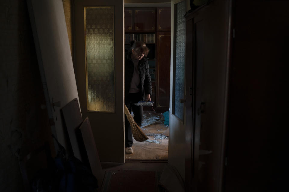 Svetlana Kondrashova cleans up shattered glass from her apartment at a residential building which was heavily damaged after a Russian attack last week in Zaporizhzhia, Ukraine, Sunday, Oct. 16, 2022. (AP Photo/Leo Correa)