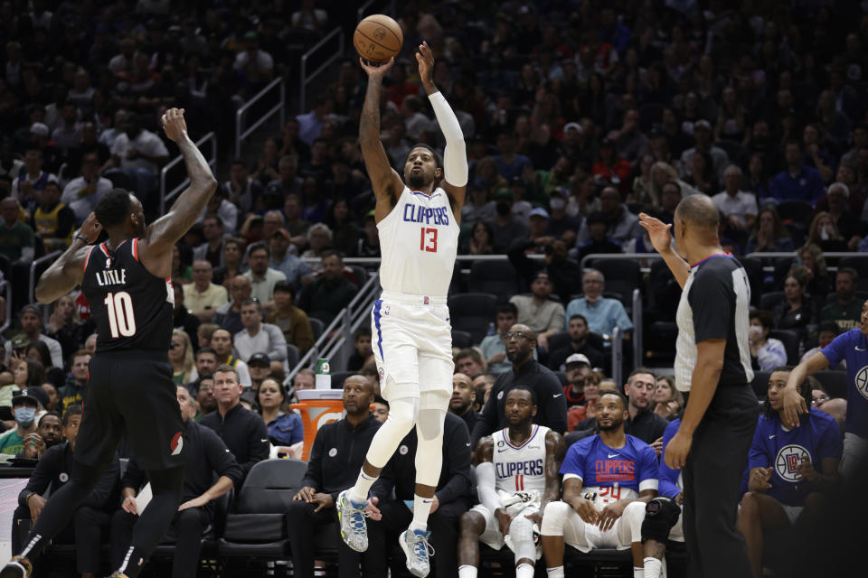 Los Angeles Clippers' Paul George shoots from the side over Portland Trailblazers' Nassir Little during the first half of a preseason NBA basketball game, Monday, Oct. 3, 2022, in Seattle. (AP Photo/ John Froschauer)