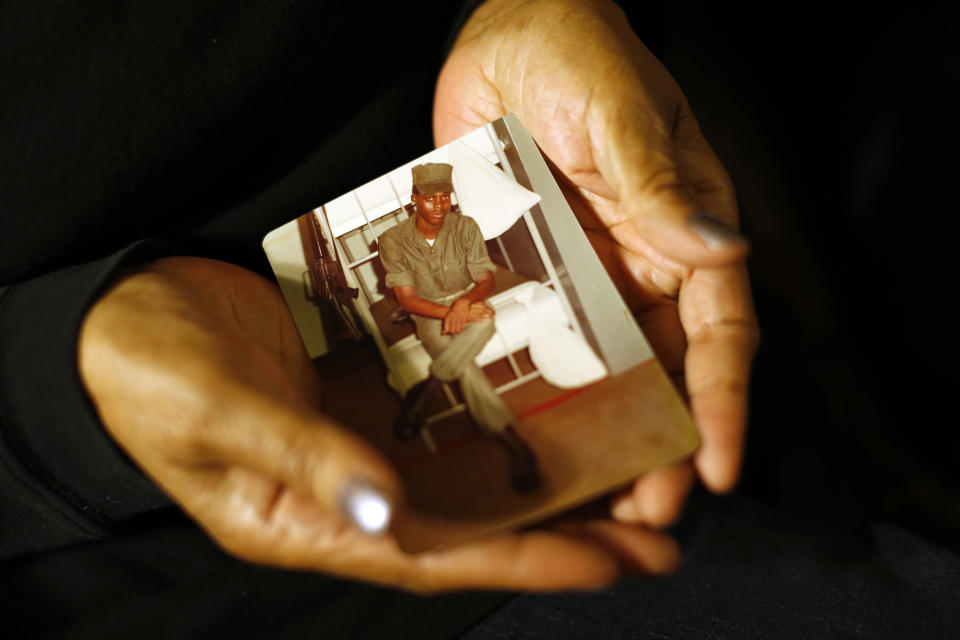 In this March 12, 2014 photo, Alma Murdough holds a photo of her son, Jerome, at her home in the Queens borough of New York. Jerome Murdough, a mentally ill, homeless former Marine arrested for sleeping in the roof landing of a New York City public housing project during one of the coldest recorded winters in city history, died last month in a Rikers Island jail cell that multiple city officials say was at least 100 degrees when his body was discovered. Murdough, 56, was found dead in his cell in a mental observation unit in the early hours of Feb. 15, after excessive heat, believed to be caused by an equipment malfunction, redirected it’s flow to his upper-level cell, the officials said. (AP Photo/Jason DeCrow)