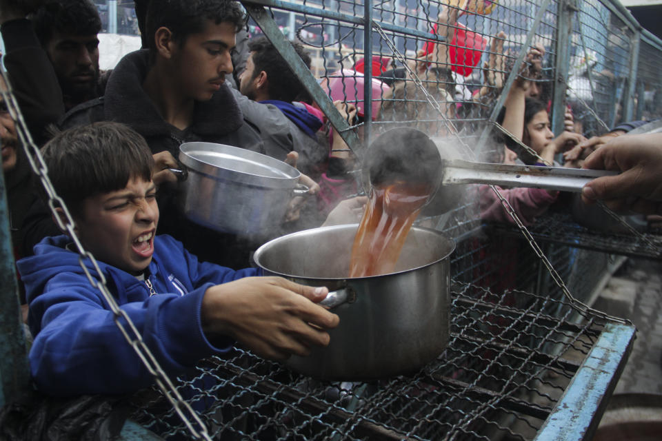 Palestinians line up to receive free meals at Jabaliya refugee camp in the Gaza Strip on Monday, March 18, 2024. (AP Photo/Mahmoud Essa)