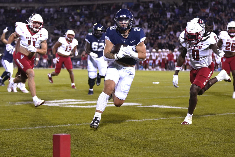 UConn running back Victor Rosa (22) runs for a touchdown against North Carolina State during the first quarter of an NCAA college football game in East Hartford, Conn., Thursday, Aug. 31, 2023. (AP Photo/Bryan Woolston)