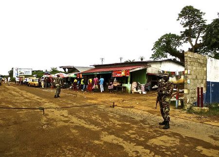 Soldiers from the Liberian army monitor a border checkpoint as part of Operation White Shield to control the Ebola outbreak, at an entrance to Bomi County in northwestern Liberia August 11, 2014. REUTERS/Sabrina Karim