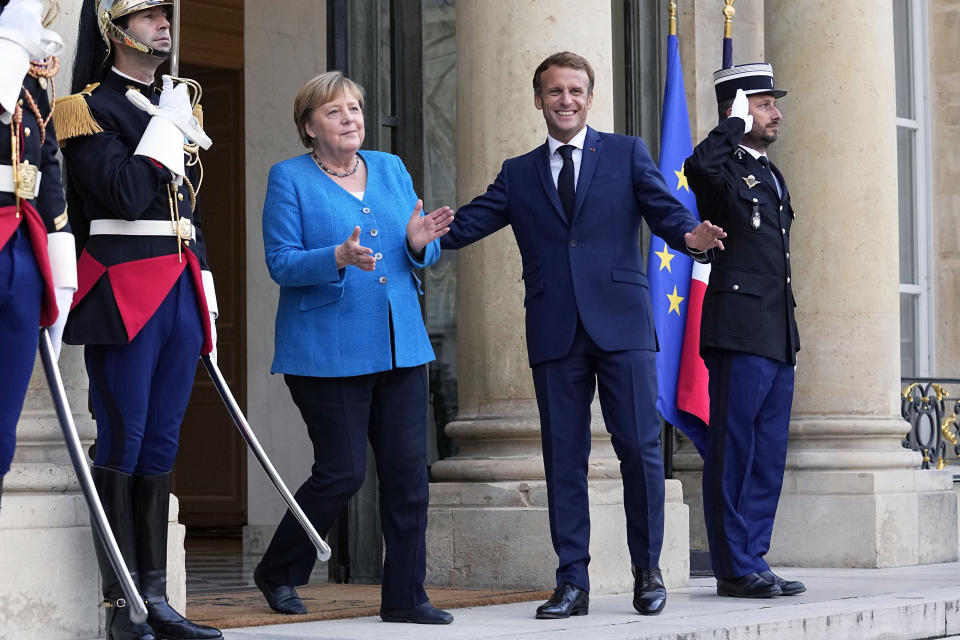 France's President Emmanuel Macron, right, welcomes German Chancellor Angela Merkel prior to a meeting at the Elysee Palace, in Paris, Thursday, Sept. 16, 2021. (AP Photo/Michel Euler)