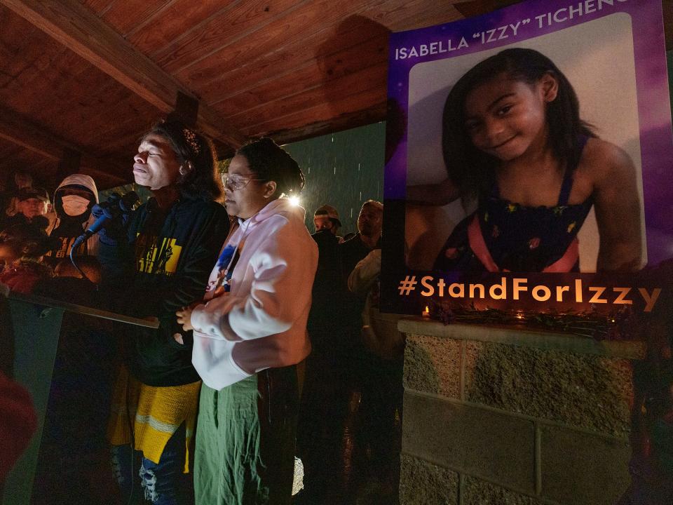 Brittany Tichenor-Cox, center, joined by her sister Jasmine Rhodes, right, speaks about her daughter as hundreds joined the Tichenor family in mourning the death of 10-year-old Isabella "Izzy" Tichenor during a vigil at Foxboro Hollow Park in North Salt Lake, Utah, Nov. 9, 2021.