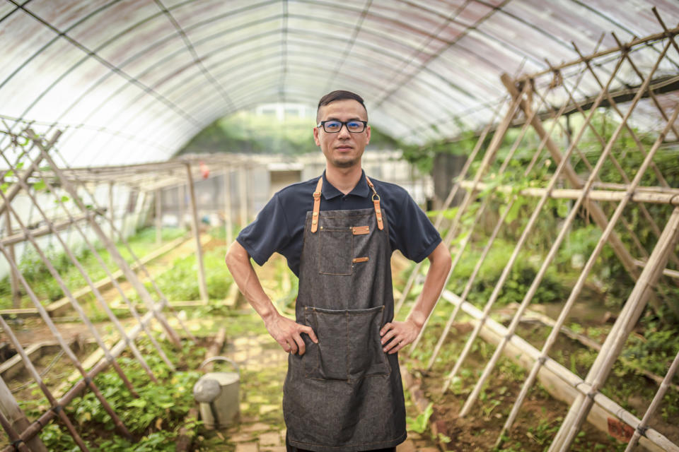 A young Asian man in a greenhouse